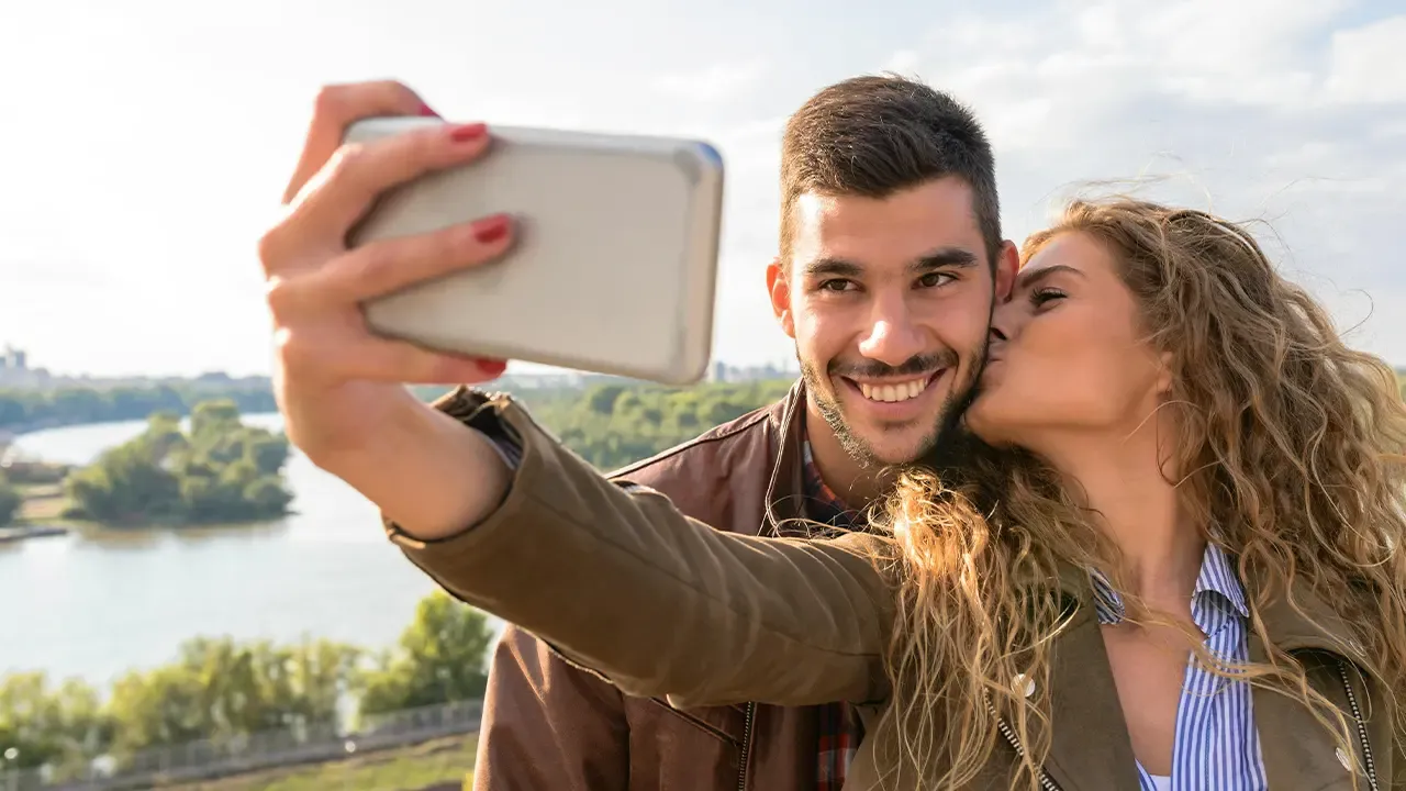En foto: Pareja tomándose una selfie. 