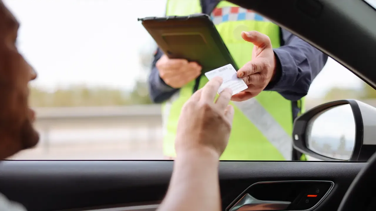 En la foto: Hombre en carro entregando licencia de transito a policia